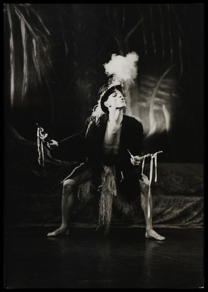 Black and white photograph of Wilbert Bradley on stage blowing smoke in L'ag'ya- A Caribbean Rhapsody