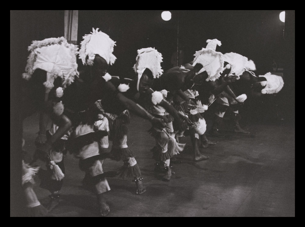 Black and white photograph of dancers on stage in Ballet Africains