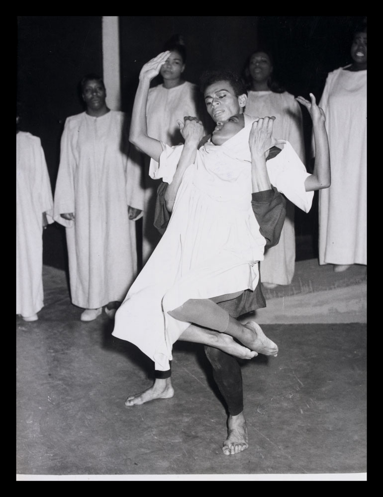 Black and white photograph of two performers on stage for Black Nativity